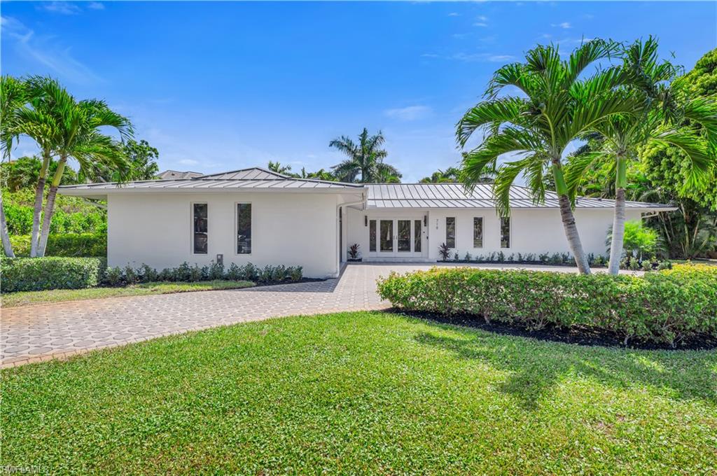 718 Old Trail Drive Naples, FL 34103 - Photo 3 of 18 Ranch-style house with stucco siding, a front lawn, a standing seam roof, and a metal roof