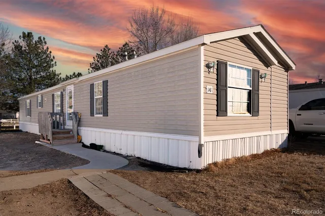 a view of a small house with wooden fence