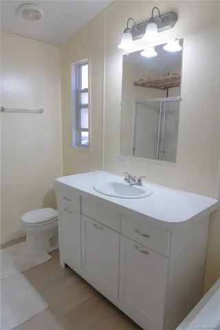a bathroom with a toilet sink and mirror