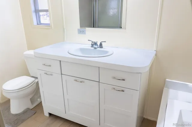 a bathroom with a sink toilet and mirror