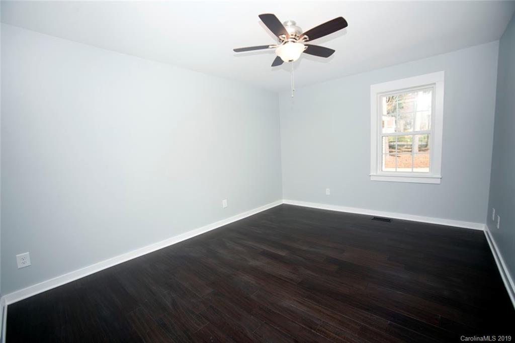 8236 Fairfield Forest Road Denver, NC 28037 - Photo 22 of 32 a view of an empty room with wooden floor and a window