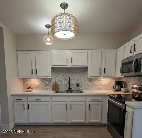 a kitchen with stainless steel appliances granite countertop a sink a stove oven a counter space and cabinets
