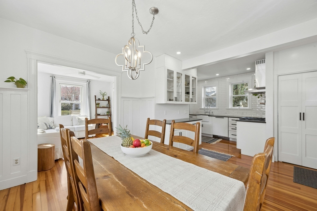 90 Florian Street Boston, MA 02130 - Photo 9 of 32 a view of a dining room and livingroom with furniture wooden floor a rug a potted plant and a chandelier
