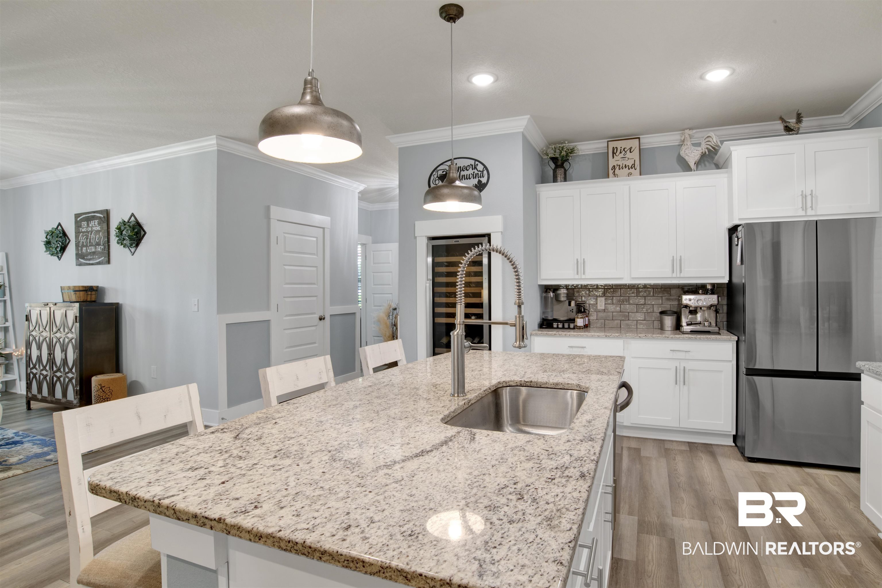 10113 Lakeview Drive Foley, AL 36535 - Photo 9 of 34 Kitchen featuring pendant lighting, white cabinets, an island with sink, sink, and stainless steel refrigerator