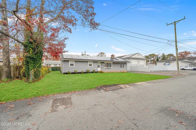 a view of a house with a big yard and large trees