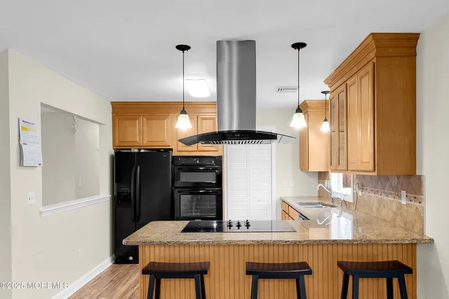 a kitchen with stainless steel appliances granite countertop a sink a stove a refrigerator a washer and dryer