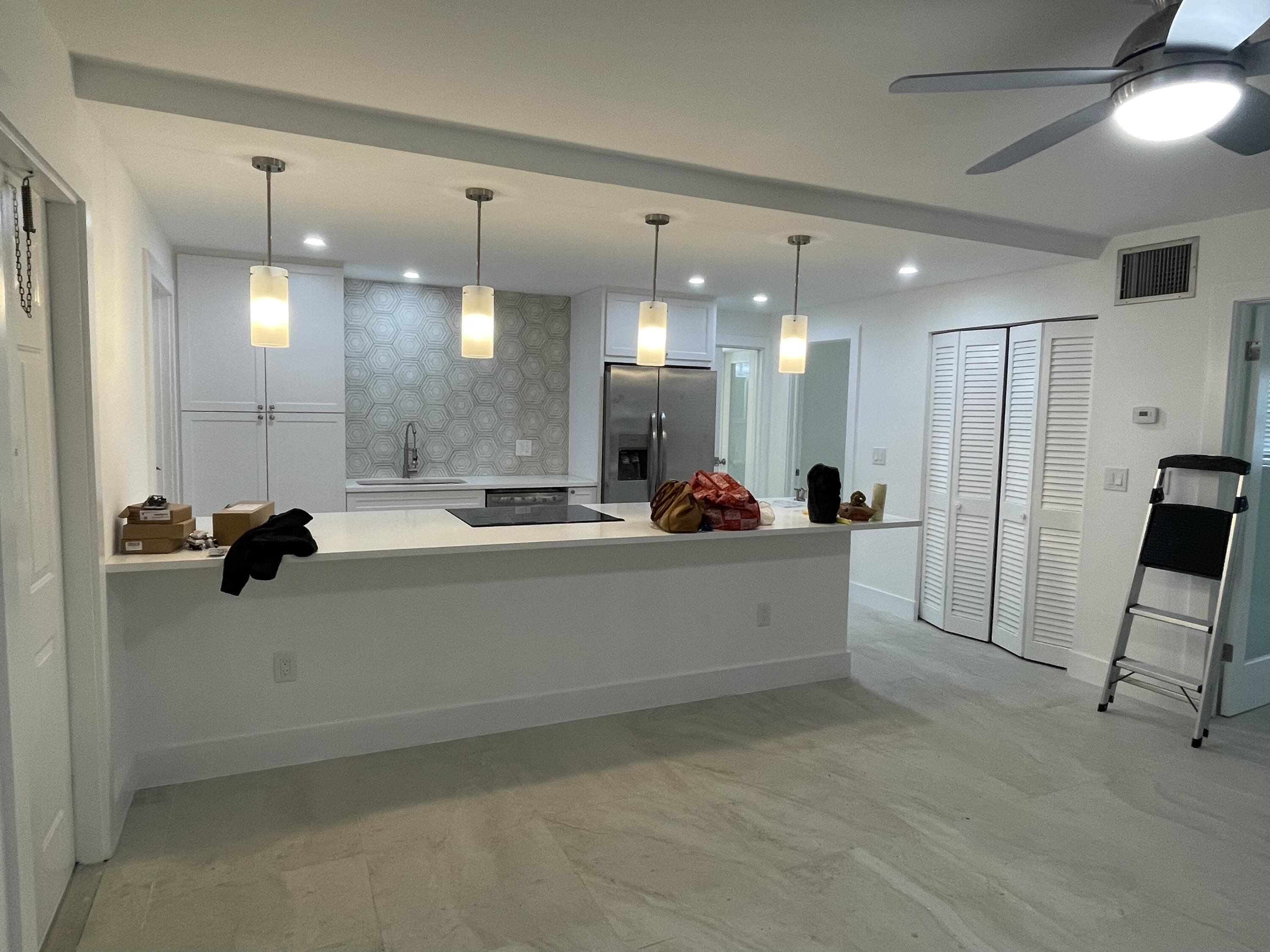 316 Southeast 1st Street, Unit 4 Boynton Beach, FL 33435 - Photo 1 of 16 a large white kitchen with a large island stainless steel appliances and furniture