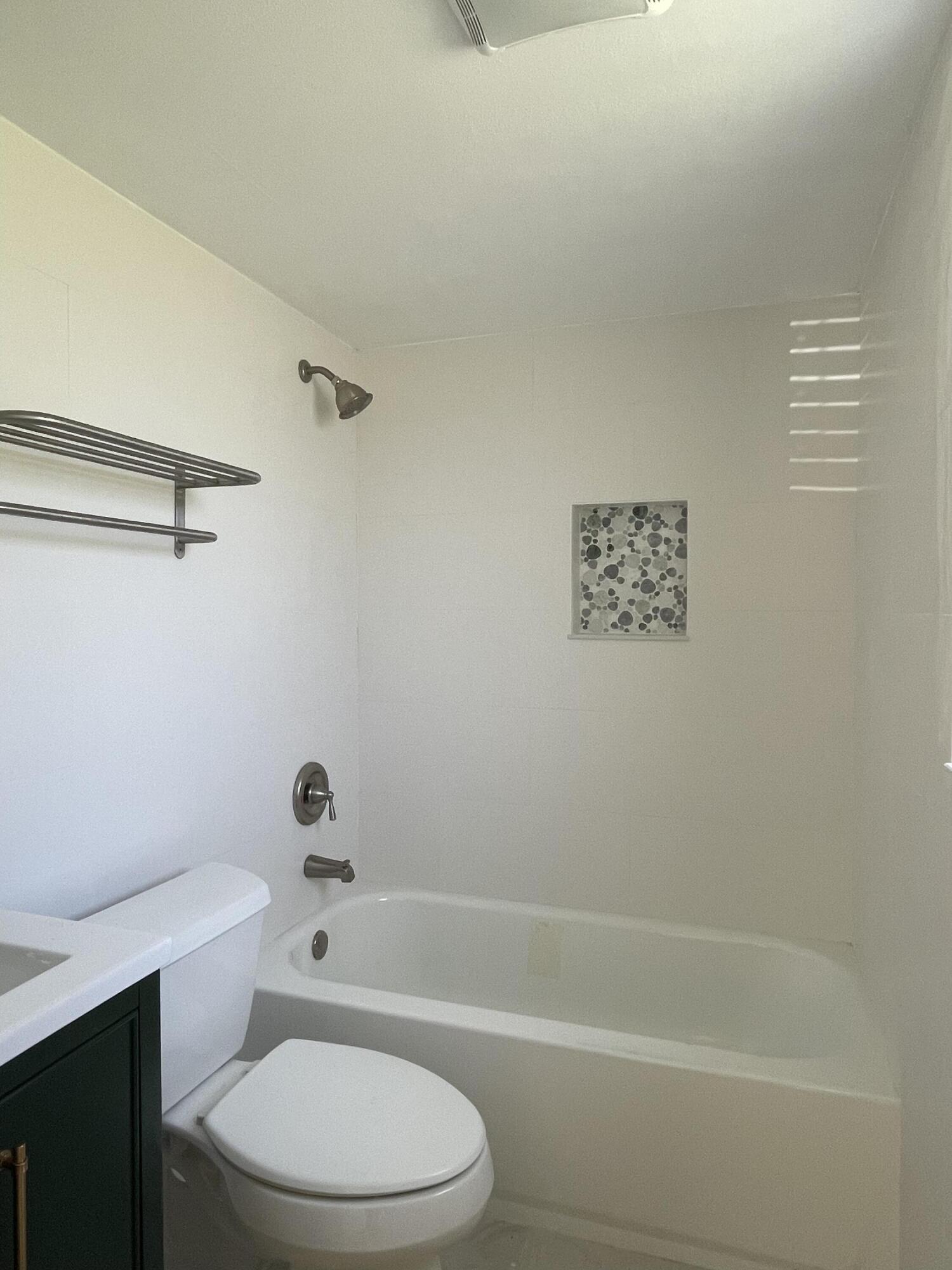 316 Southeast 1st Street, Unit 4 Boynton Beach, FL 33435 - Photo 4 of 16 a white toilet and tub sitting next to a bathroom sink