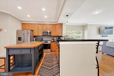 a kitchen with stainless steel appliances granite countertop a refrigerator and a stove top oven