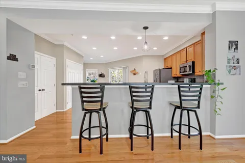 a view of kitchen with stainless steel appliances kitchen island microwave and wooden floor