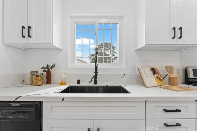 a kitchen with cabinets appliances and wooden floor