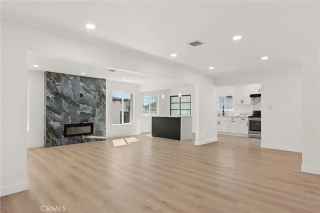 a view of an empty room with furniture and fireplace