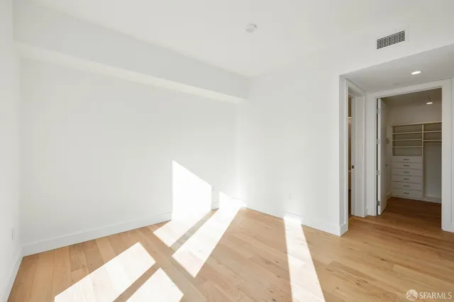 a view of a room with wooden floor and a hallway