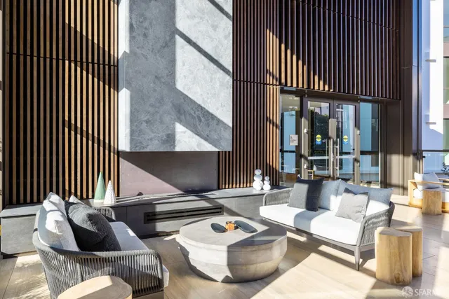 a living room with couches and kitchen view with wooden floor