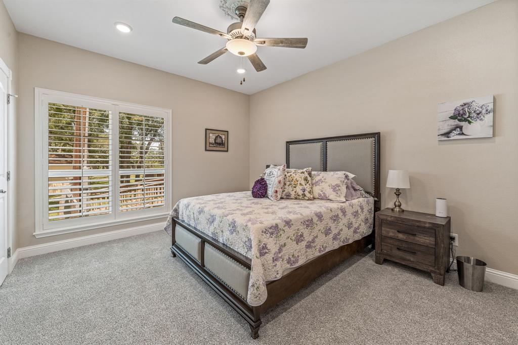 1340 County Road 189 Jonesboro, TX 76538 - Photo 16 of 39 a spacious bedroom with a bed a dresser and a chandelier