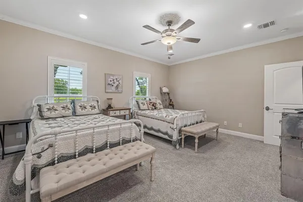 a spacious bedroom with a bed and a chandelier