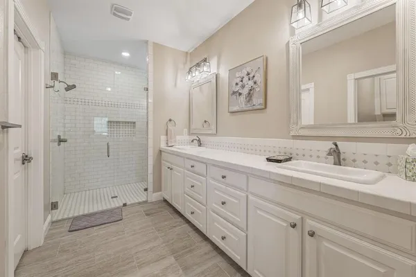 a spacious bathroom with double sink and a mirror