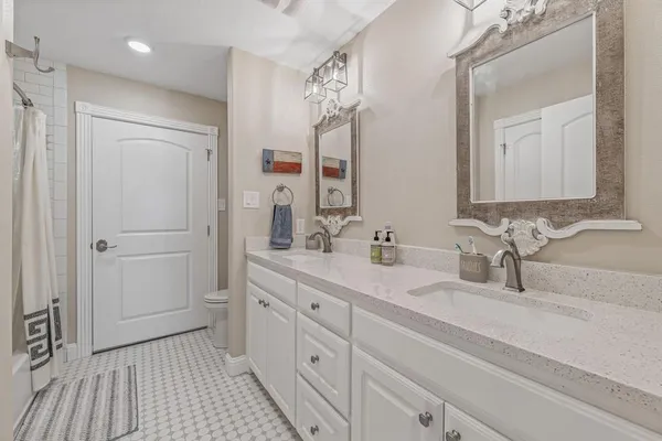 a bathroom with a double vanity sink a mirror and a shower