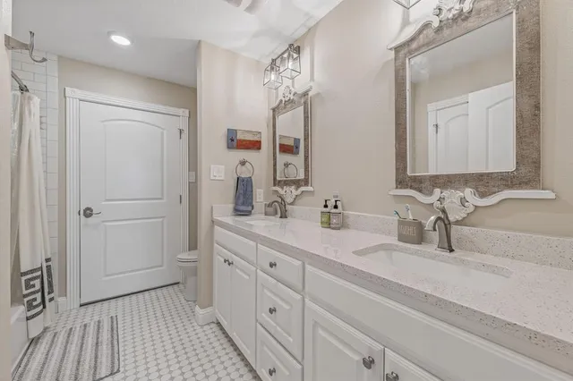 a bathroom with a double vanity sink a mirror and a shower