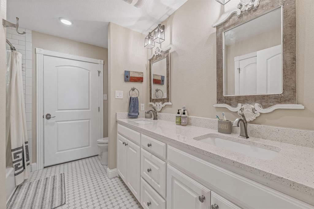 1340 County Road 189 Jonesboro, TX 76538 - Photo 20 of 39 a bathroom with a double vanity sink a mirror and a shower
