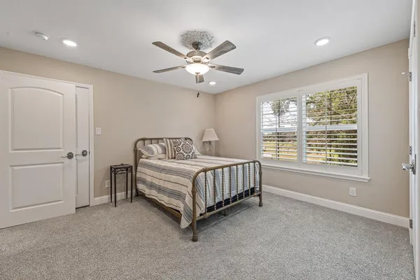 a spacious bedroom with a bed and a chandelier