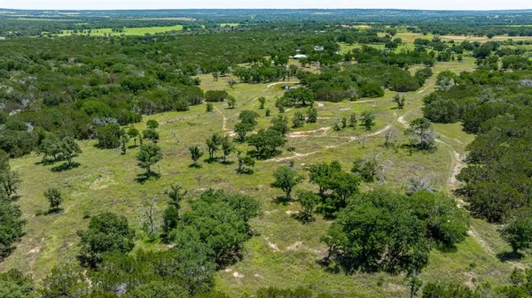 an aerial view of residential houses with outdoor space and trees