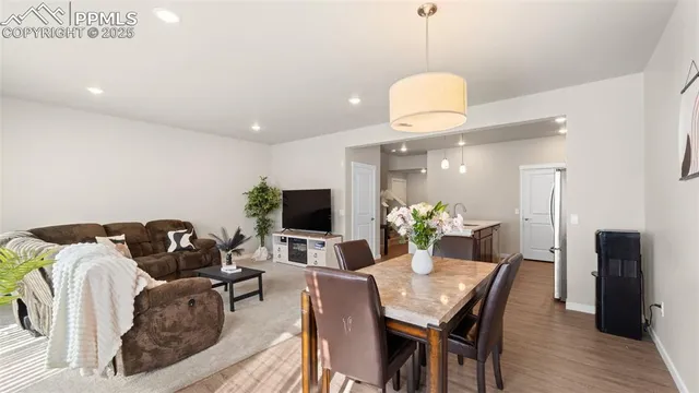 a living room with furniture a flat screen tv and a chandelier