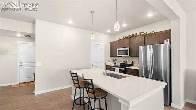 a kitchen with a refrigerator a dining table and chairs