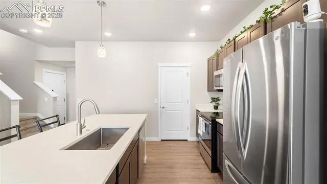 a kitchen with kitchen island a sink appliances and cabinets
