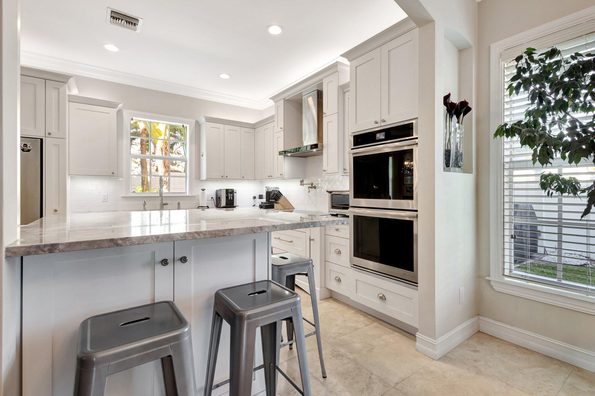 213 Kings Lynn Delray Beach, FL 33444 - Photo 11 of 39 a kitchen with stainless steel appliances a stove a sink and a microwave