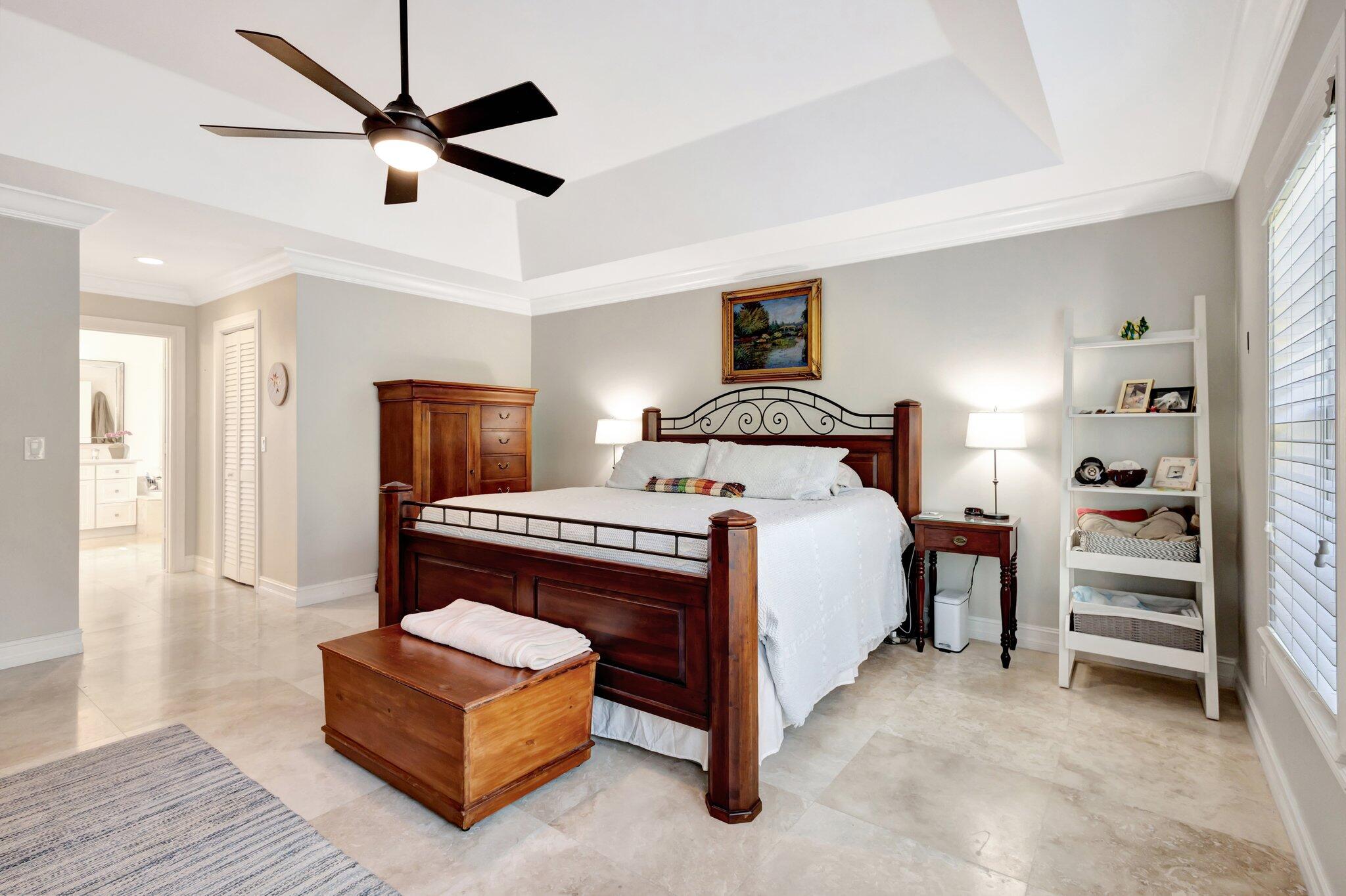 213 Kings Lynn Delray Beach, FL 33444 - Photo 17 of 39 a bedroom with a bed and a chandelier