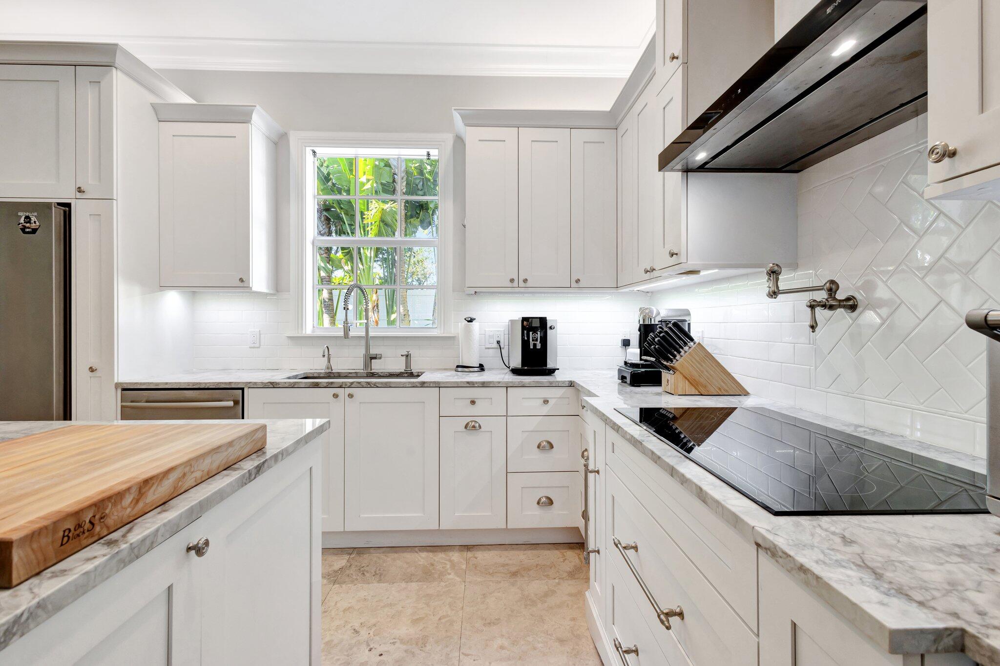 213 Kings Lynn Delray Beach, FL 33444 - Photo 3 of 39 a kitchen with granite countertop white cabinets white appliances a sink and a window