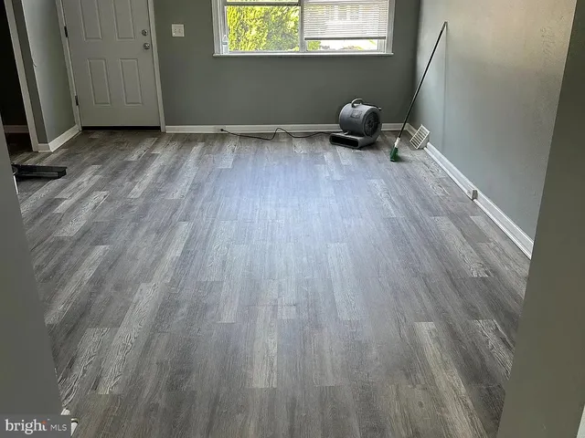 a room with wooden floor and a window