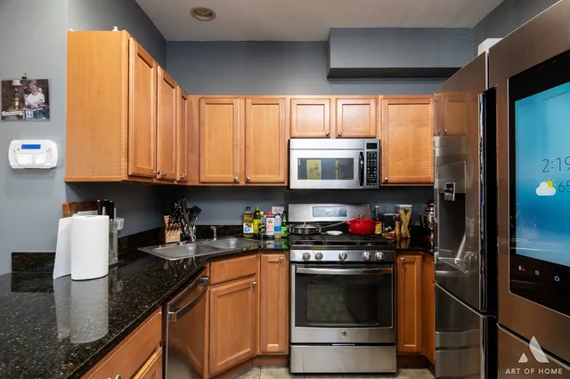 a kitchen with stainless steel appliances granite countertop a stove a sink and a microwave