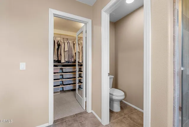 a view of a hallway with wooden floor and a bathroom