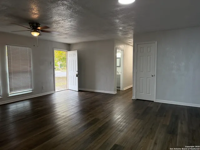 an empty room with wooden floor and windows