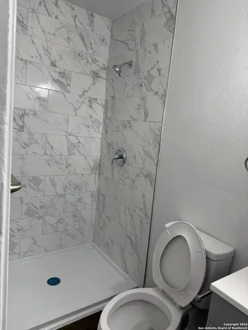 a bathroom with a toilet and a shower