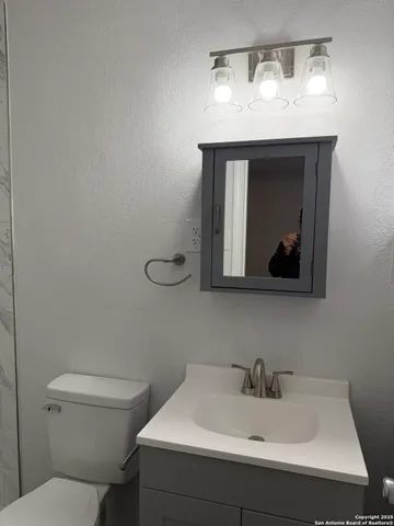a bathroom with a toilet sink and mirror