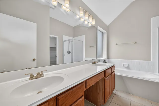 a bathroom with a sink double vanity granite tub and a mirror