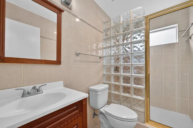 a bathroom with a sink a toilet a mirror and shower