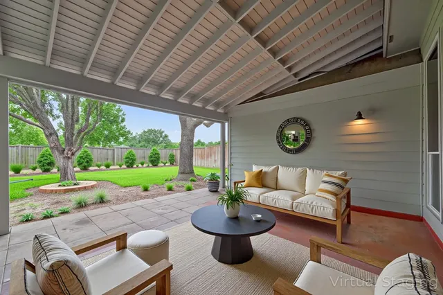 a living room with patio furniture and a garden