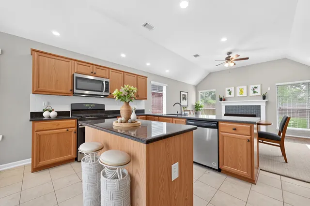 a kitchen with stainless steel appliances granite countertop a sink dishwasher stove and refrigerator
