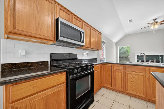 a kitchen with stainless steel appliances granite countertop a stove microwave and sink