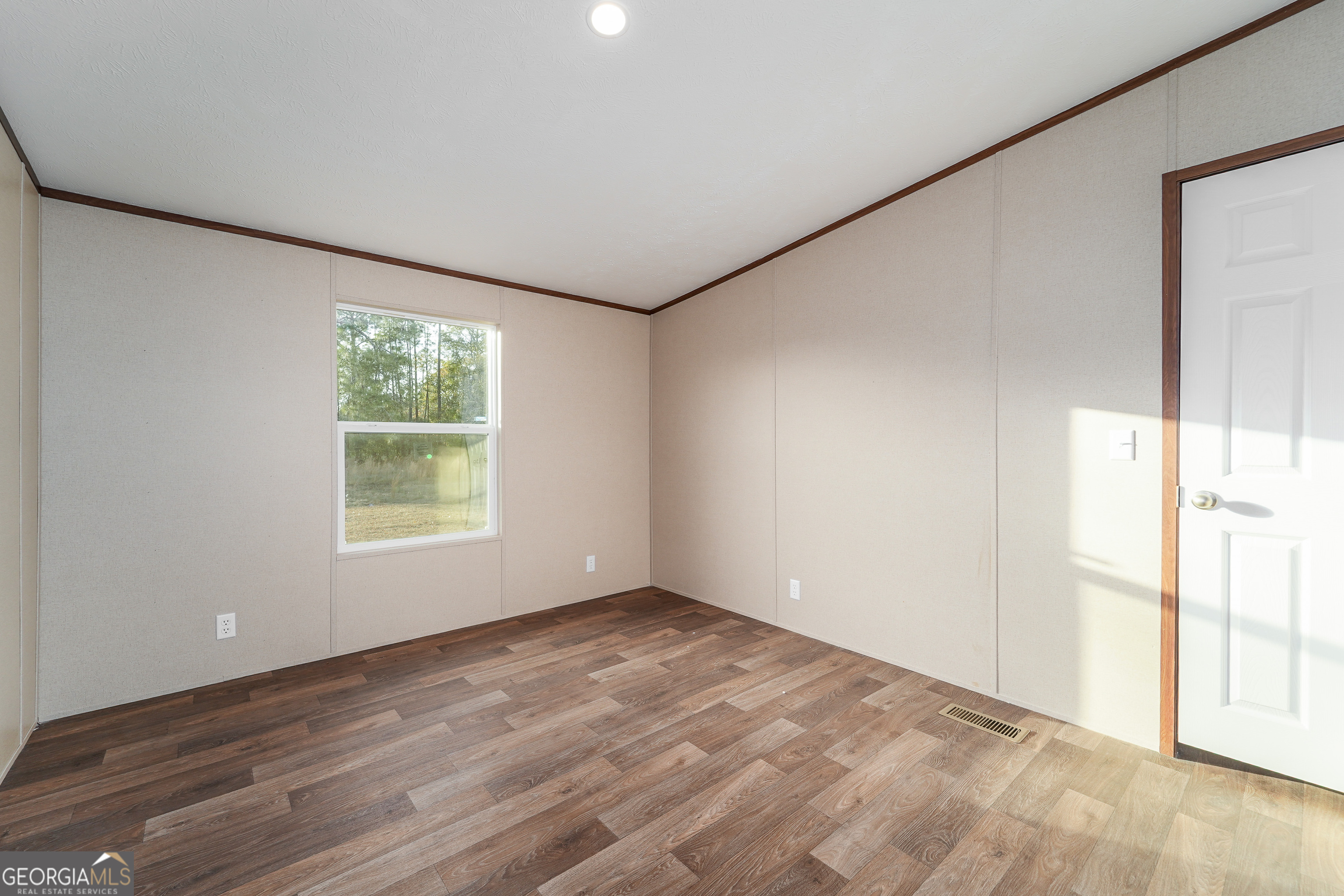 1808 Brunel Street Waycross, GA 31503 - Photo 16 of 26 an empty room with wooden floor and windows