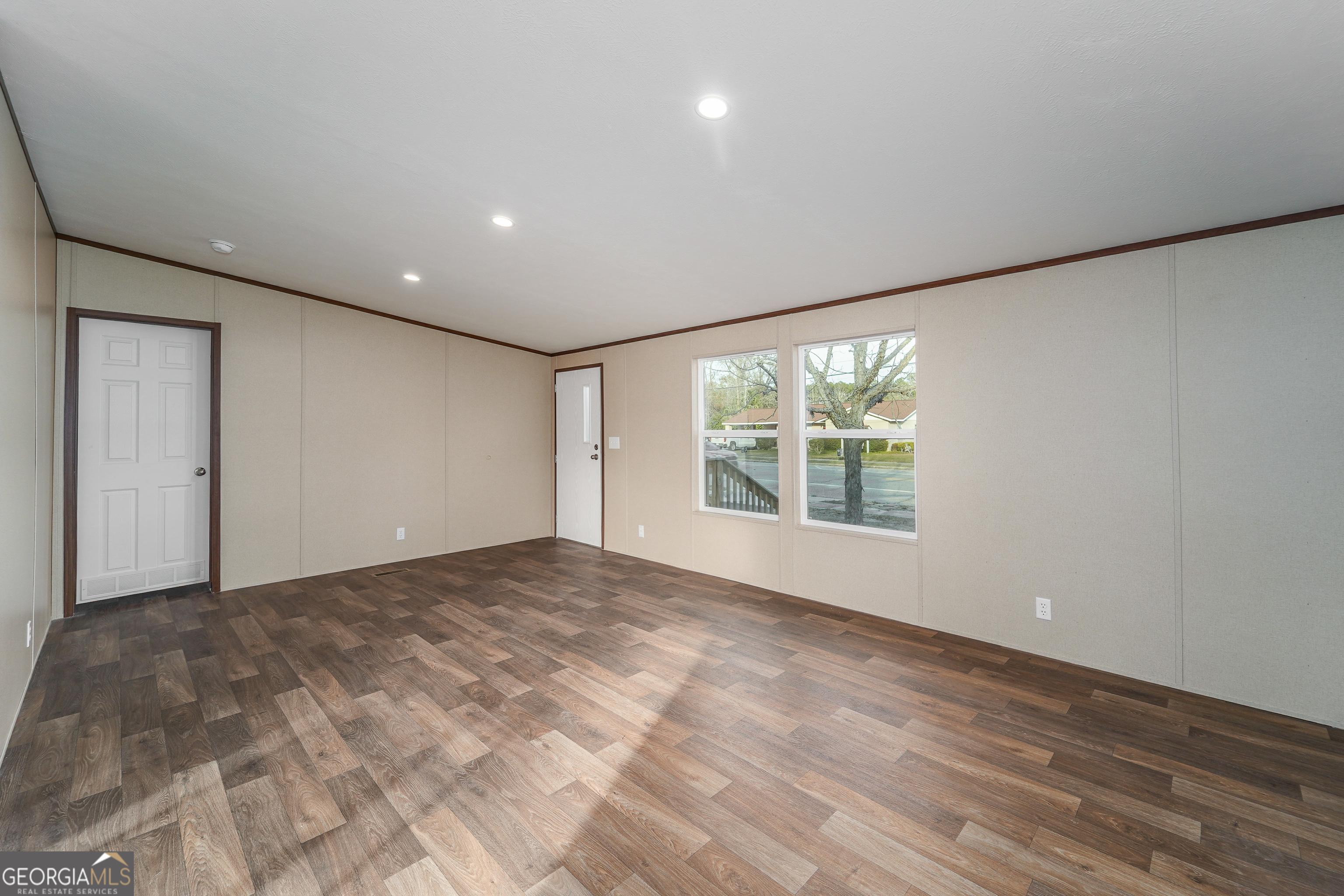 1808 Brunel Street Waycross, GA 31503 - Photo 6 of 26 a view of an empty room with wooden floor and a window