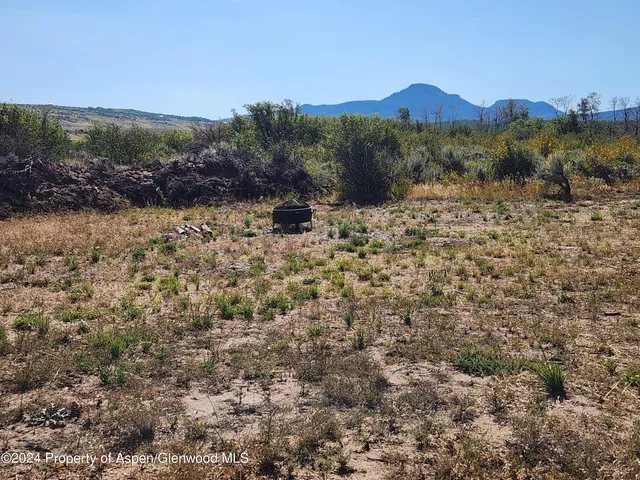 a view of a mountain range with lush green forest