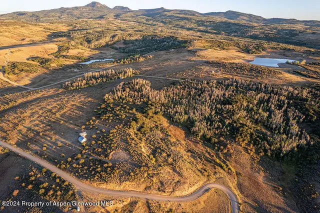 a view of a dry yard with mountains in the background