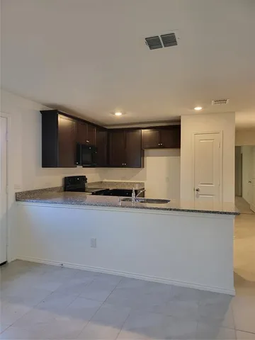 a view of kitchen with stainless steel appliances kitchen island sink stove and cabinets