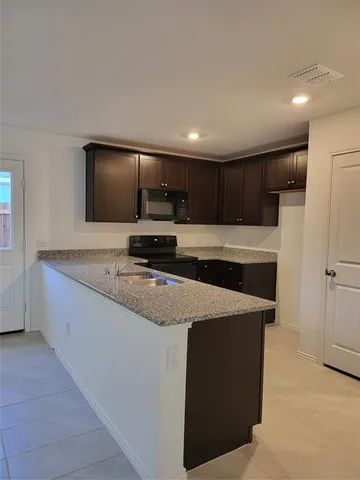 a kitchen with kitchen island a counter top space appliances and cabinets
