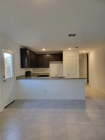 a view of kitchen with stainless steel appliances kitchen island granite countertop a stove a sink a refrigerator and white cabinets